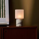 Cordless table lamp with Calacatta Vionaro marble base glowing on a bedroom dresser