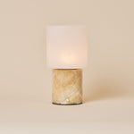 Cuyp Honey Onyx Marble Rechargeable Table Lamp glowing on a cream studio backdrop