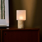 Rechargeable table lamp with honey onyx marble base glowing on a walnut cabinet at dusk