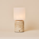 Cuyp Large rechargeable table lamp with a beige travertine base and glowing frosted glass shade