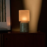 Cuyp Large rechargeable table lamp glowing beside stacked books on a dark wood cabinet