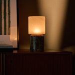 Tavellio Cuyp Large rechargeable table lamp in Emperador dark marble glowing beside a framed print at dusk