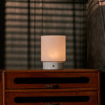 Cuyp Small rechargeable table lamp in Bianco Statuarietto marble glowing on a vintage wood dresser