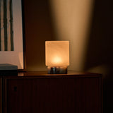 Cuyp Small cordless table lamp, Calacatta Viola marble, glowing softly under blind-shadow lighting