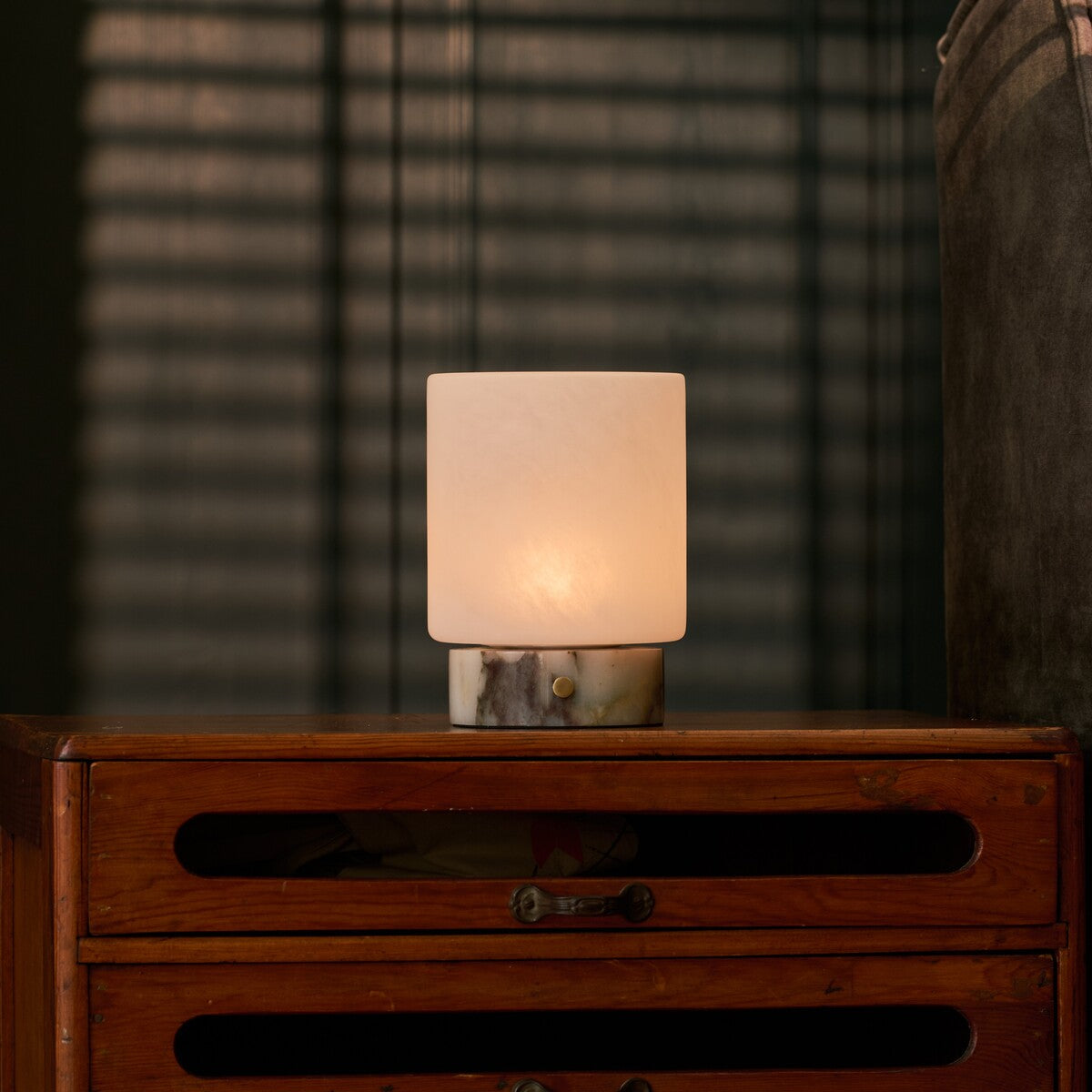 Rechargeable table lamp Cuyp Small, Calacatta Viola marble, lit atop an antique wooden dresser