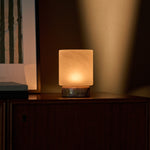 Tafellamp oplaadbaar Cuyp Small in roze Calacatta Vionaro marmer op een donker houten dressoir naast gestreepte wandkunst