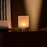 Tavellio cordless table lamp Cuyp Small in Calacatta Vionaro marble on a tiled counter with citrus tree
