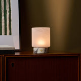 Cordless table lamp Cuyp Small, Calacatta Vionaro marble, glowing on a wood cabinet at dusk