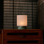 Cuyp Small rechargeable table lamp in Ice Green marble glowing on a vintage wood dresser at dusk