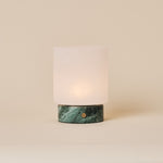 Cuyp Small rechargeable table lamp in Ice Green marble glowing on a plain beige studio backdrop