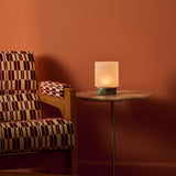 Tavellio Cuyp Small cordless table lamp in Ice Green marble on a side table beside a patterned armchair