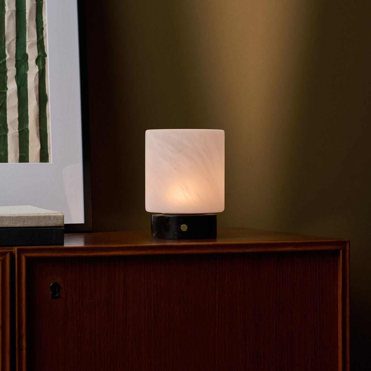 Cuyp cordless table lamp with Nero Marquina base on a wood cabinet against an olive green wall
