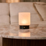 Cuyp rechargeable table lamp in Nero Marquina marble reflected on a marble side table beside a beige sofa