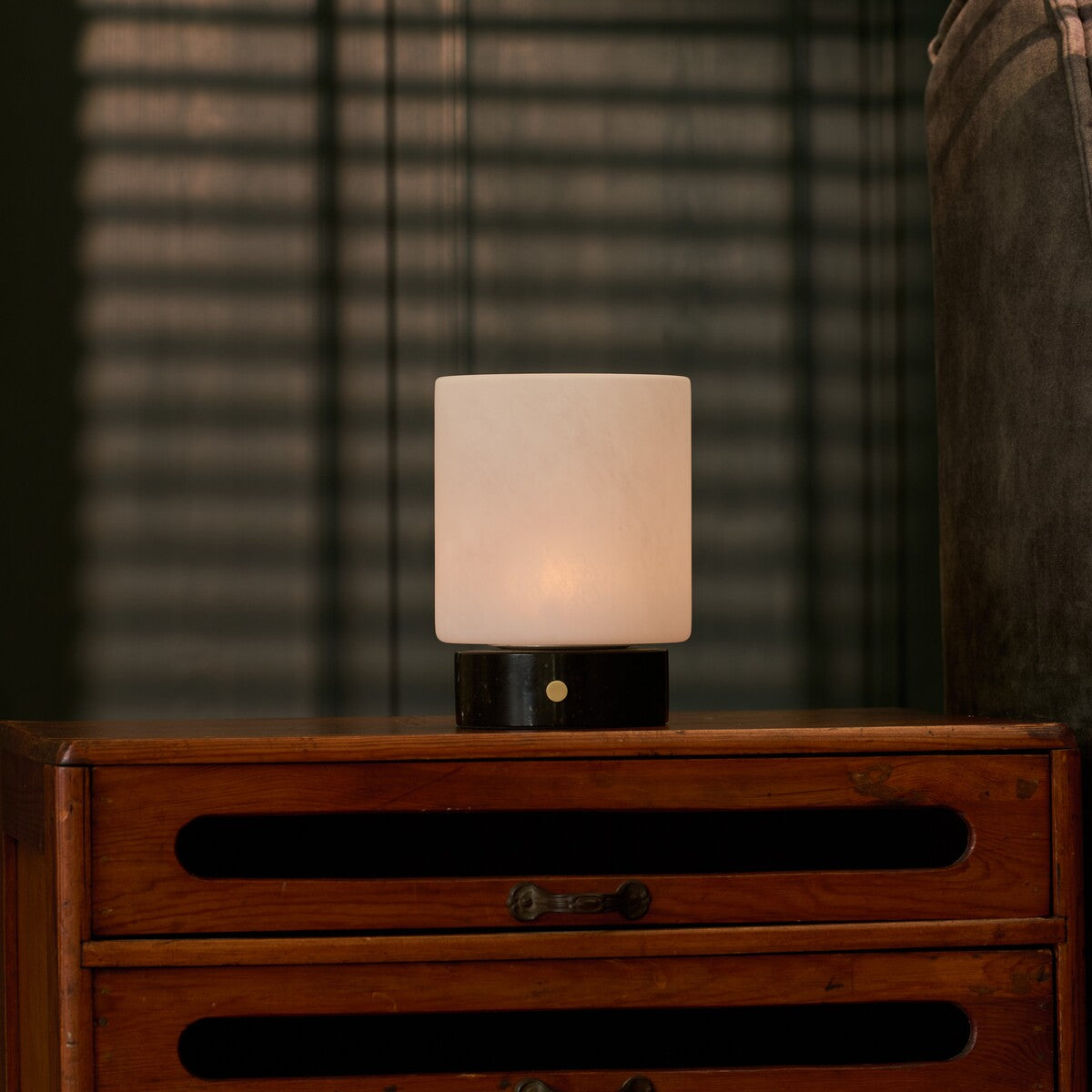 Cuyp rechargeable table lamp with black marble base on a nightstand under venetian blind shadows