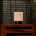 Cuyp rechargeable table lamp with black marble base on a nightstand under venetian blind shadows