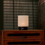 Cuyp rechargeable table lamp with black marble base on a nightstand under venetian blind shadows