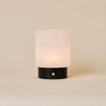 Cuyp cordless table lamp with Nero Marquina black marble base and frosted glass shade on beige backdrop
