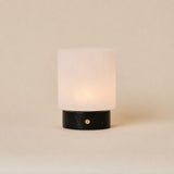 Cuyp cordless table lamp with Nero Marquina black marble base and frosted glass shade on beige backdrop