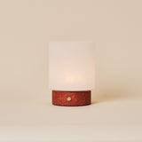 Lampe de table Cuyp Small travertin rouge sans fil Tavellio - photo studio, socle en travertin poreux et abat-jour en verre dépoli