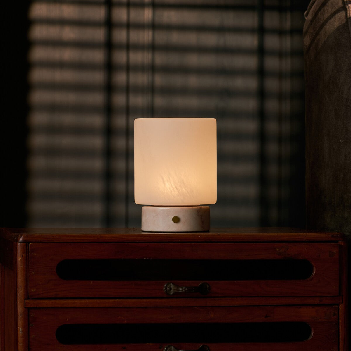 Cuyp Small Rosa Aurora lampe de table rechargeable Tavellio – sur une commode sombre le soir, ombres rayées d'un store projetées au mur