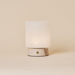 Cuyp Small Rosa Aurora lampe de table sans fil Tavellio – photo studio sur fond beige, bouton tactile doré sur la base en marbre
