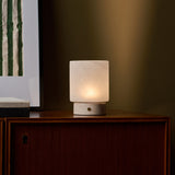 Cuyp Small Rosa Aurora lampe de table rechargeable Tavellio – sur un meuble en bois foncé près d'une estampe rayée verte et beige