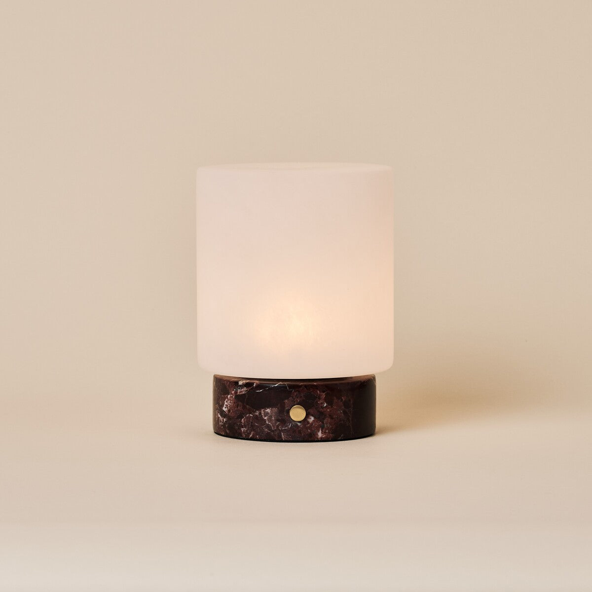 Cuyp cordless table lamp with Rosso Levanto red marble base and frosted glass shade on beige backdrop