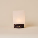 Cuyp cordless table lamp with Rosso Levanto red marble base and frosted glass shade on beige backdrop