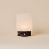 Cuyp cordless table lamp with Rosso Levanto red marble base and frosted glass shade on beige backdrop