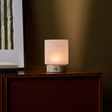 Cuyp Small cordless table lamp glowing on a wood cabinet beside a green striped print
