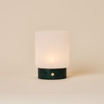 Cuyp Small rechargeable table lamp in Verde Alpi green marble glowing on a plain beige studio backdrop