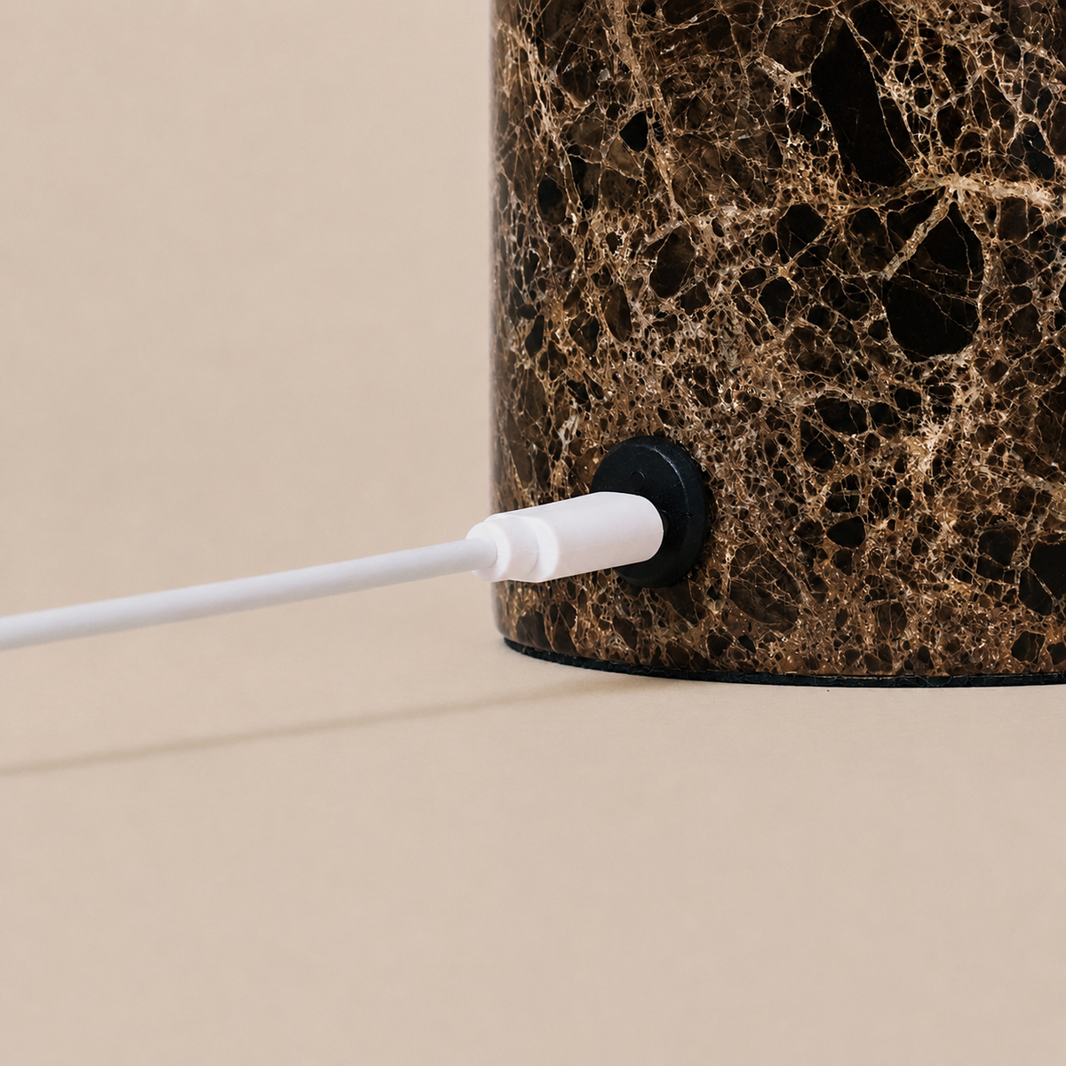 Close-up of the Keyser rechargeable table lamp's charging cable set into Emperador dark marble
