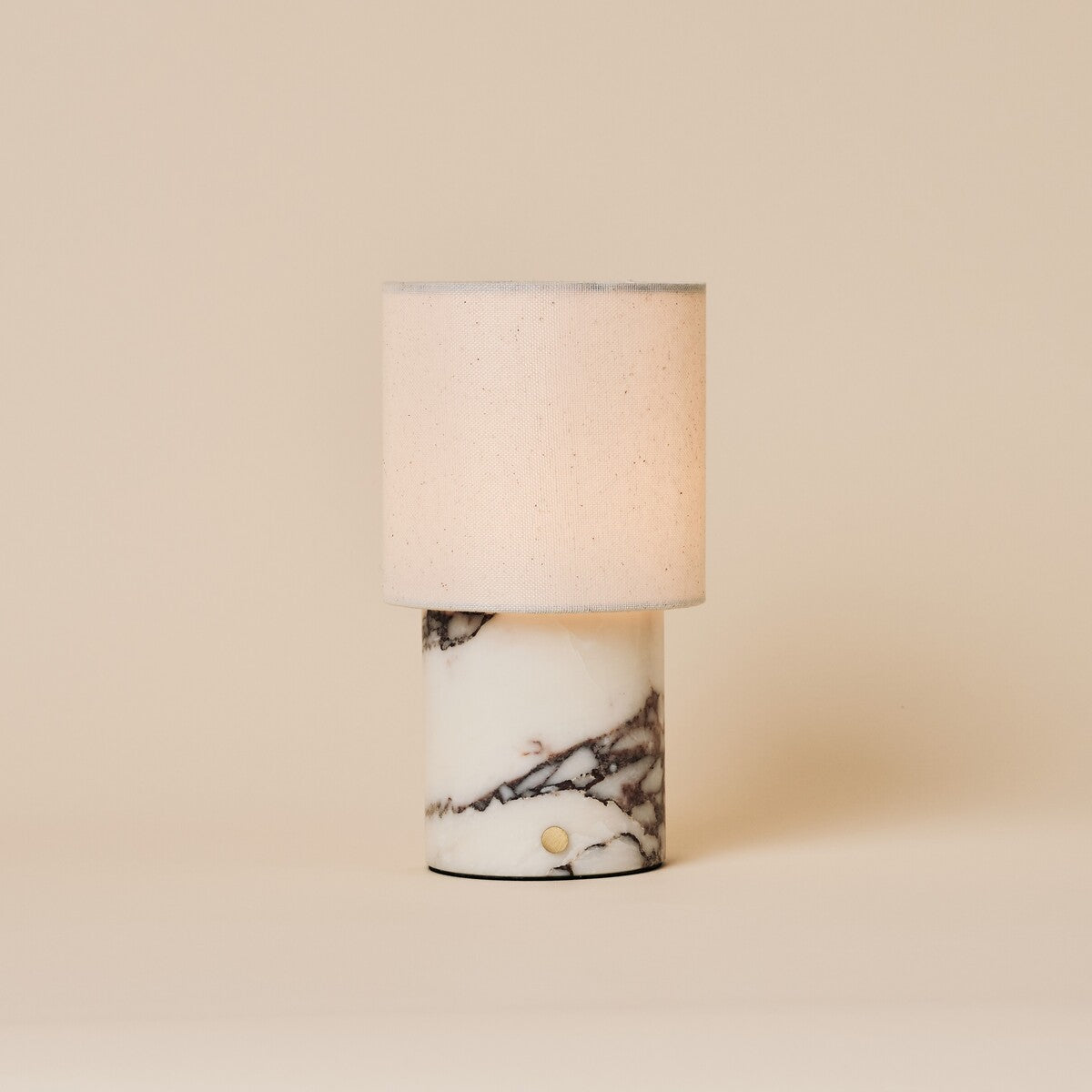 Dou Calacatta Vionaro lampe de table sans fil Tavellio – photo studio sur fond beige – bouton tactile doré sur marbre veiné