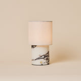 Dou Calacatta Vionaro lampe de table sans fil Tavellio – photo studio sur fond beige – bouton tactile doré sur marbre veiné
