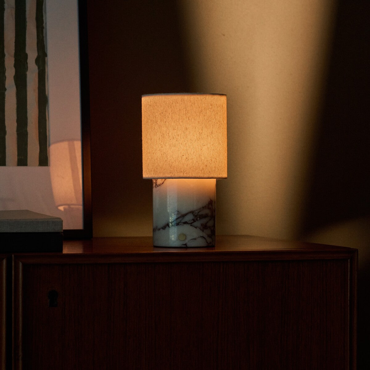 Dou Calacatta Vionaro lampe de table sans fil Tavellio – allumée sur un chevet dans une chambre tamisée – veinure brune sur marbre blanc