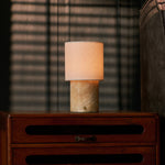 Dou rechargeable table lamp beside a striped throw blanket on a wood dresser, golden Honey Onyx marble base
