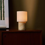 Dou rechargeable table lamp on a walnut sideboard, Honey Onyx marble base beside striped wall art