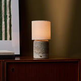 Tavellio Dou Large Silver Travertine table lamp beside a green striped art print on a cabinet