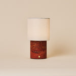Dou Red Travertine rechargeable table lamp with natural linen shade on a warm beige backdrop