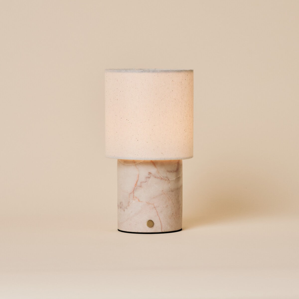 Dou Rosa Aurora lampe de table sans fil Tavellio – photo studio sur fond beige – marbre rose pâle veiné de corail