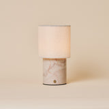 Dou Rosa Aurora lampe de table sans fil Tavellio – photo studio sur fond beige – marbre rose pâle veiné de corail