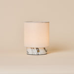 Dou Small Arabescato Marble Rechargeable Table Lamp with a cream linen shade on a neutral studio backdrop