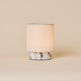 Dou Small Arabescato Marble Rechargeable Table Lamp with a cream linen shade on a neutral studio backdrop