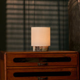 Dou Small rechargeable table lamp in Calacatta Viola marble glowing atop a vintage chest of drawers