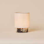 Rechargeable table lamp Dou Small in Calacatta Viola marble with natural linen shade on beige backdrop