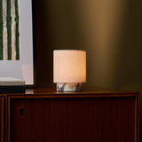 Dou Small cordless table lamp in Calacatta Vionaro marble beside striped wall art, evening light