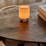 Dou Small rechargeable table lamp in Calacatta Vionaro marble on a wooden table beside books