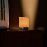 Dou Small rechargeable table lamp in Ice Green marble lit atop a vintage chest of drawers