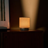Dou Small rechargeable table lamp in Ice Green marble lit atop a vintage chest of drawers