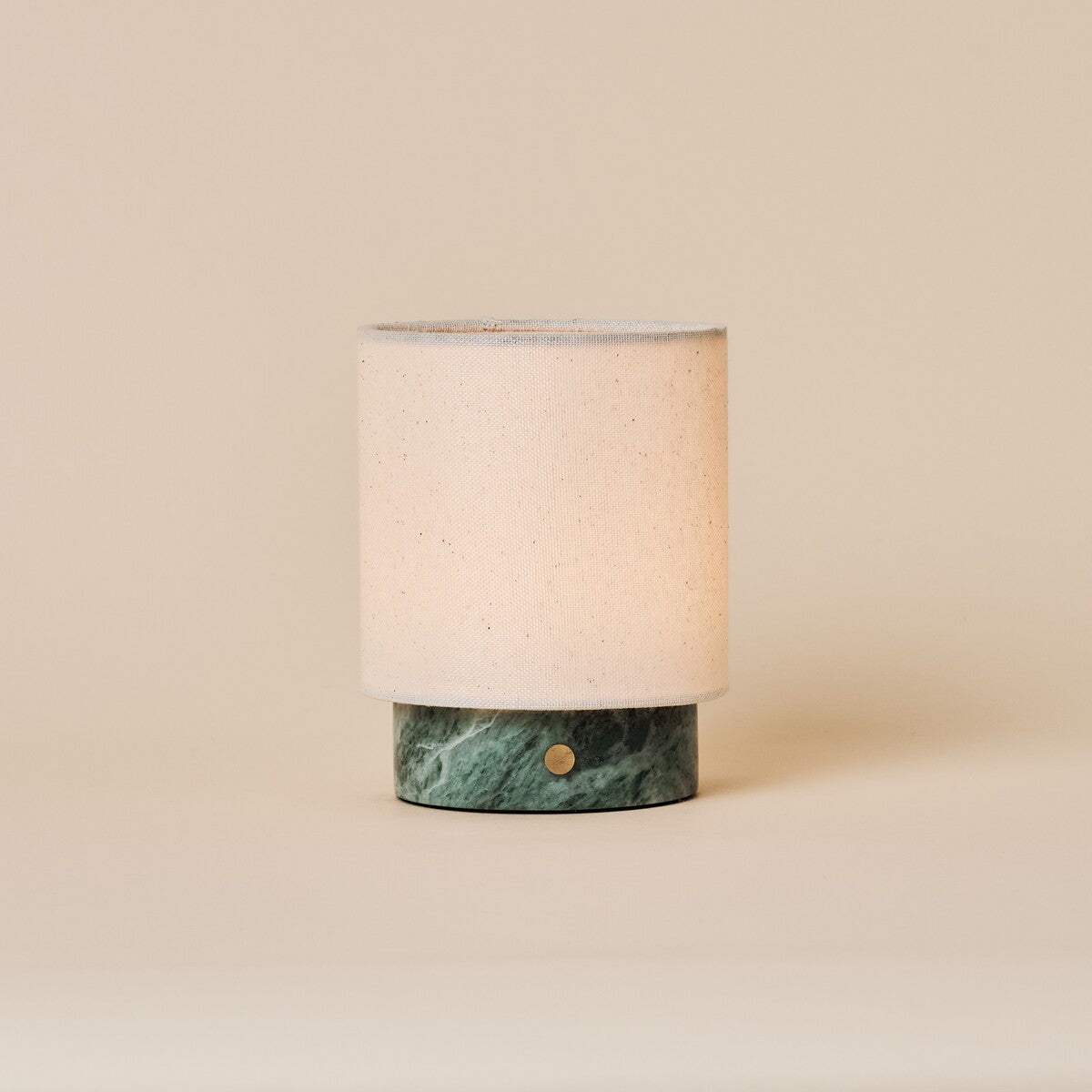 Rechargeable table lamp Dou Small in Ice Green marble with natural linen shade on beige backdrop